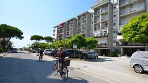 Ein mehrstöckiges Wohngebäude mit Balkonen und einer Straße davor.