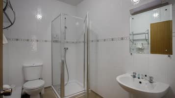 Bañera con ducha, toallas, jabón, shampoo