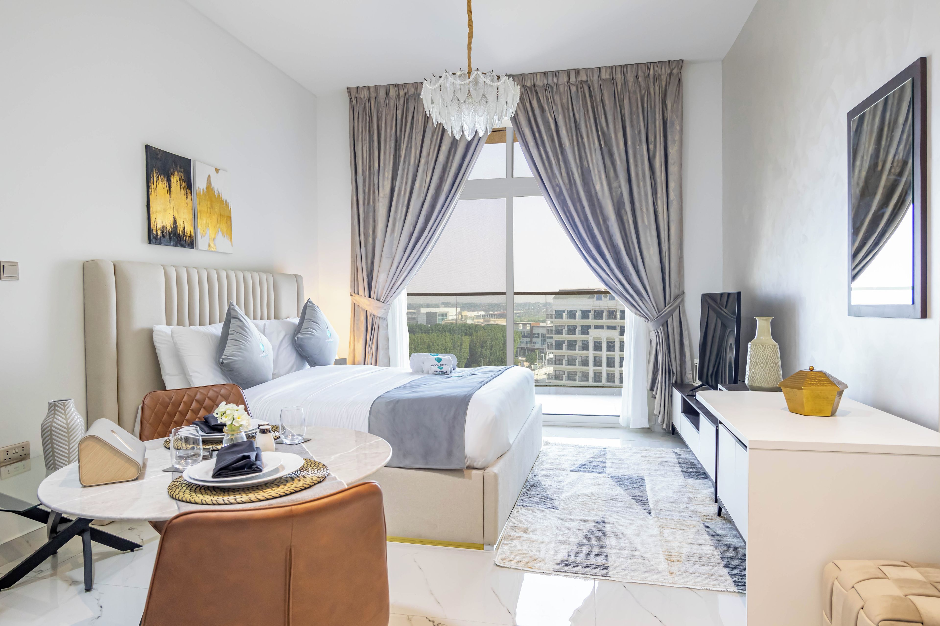 Ein modernes Hotelzimmer mit einem großen Bett, einem Essbereich und Blick auf die Stadt.