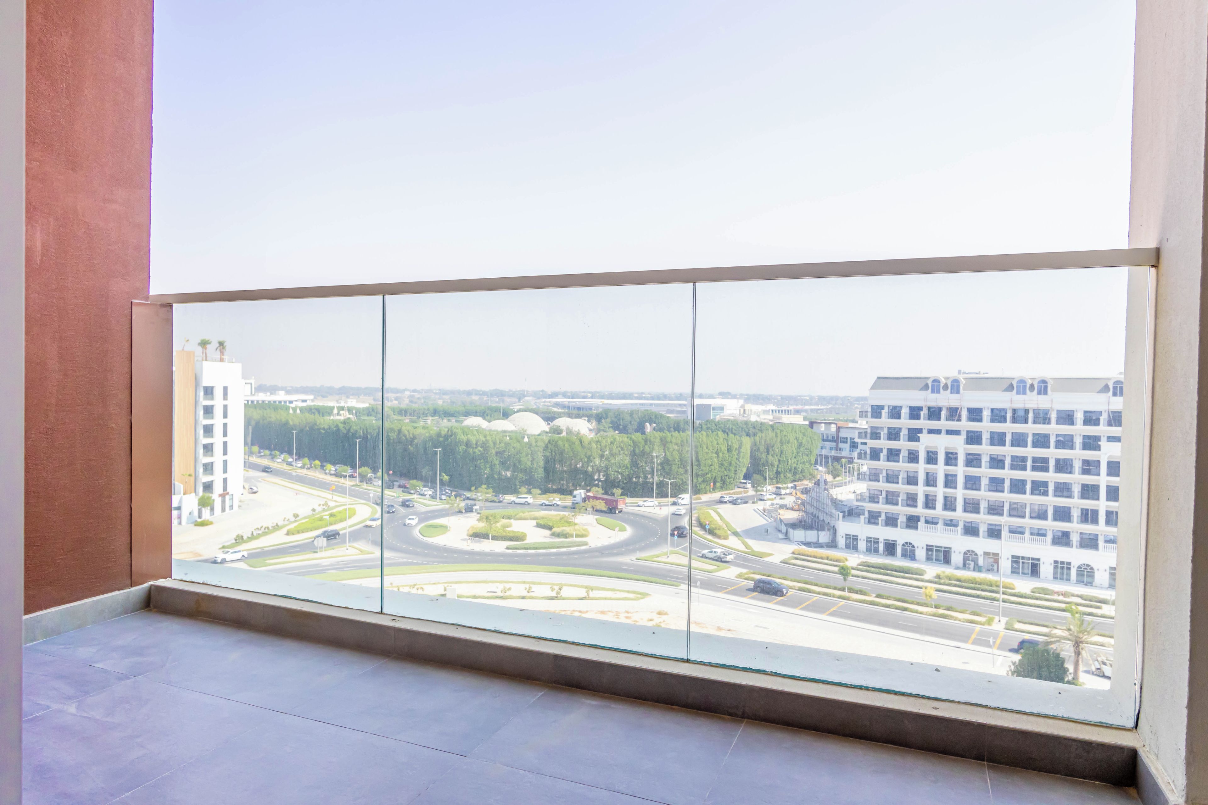 A room with a large window overlooking a cityscape with buildings and roads.