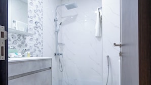 Moderni kylpyhuone, jossa on suihku, wc ja pesuallas.