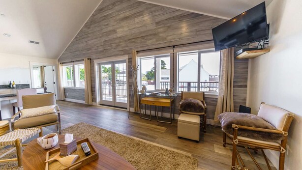 A spacious living area with a high ceiling, large windows, and a flat-screen TV mounted on the wall. - Ocean "Front" Lux, 3 Living Rooms: SeaView House (Crescent city)