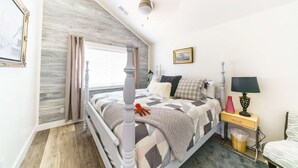 A bedroom with a bed, a nightstand, a lamp, a chair, and a window with curtains. - Ocean "Front" Lux, 3 Living Rooms: SeaView House (Crescent city)