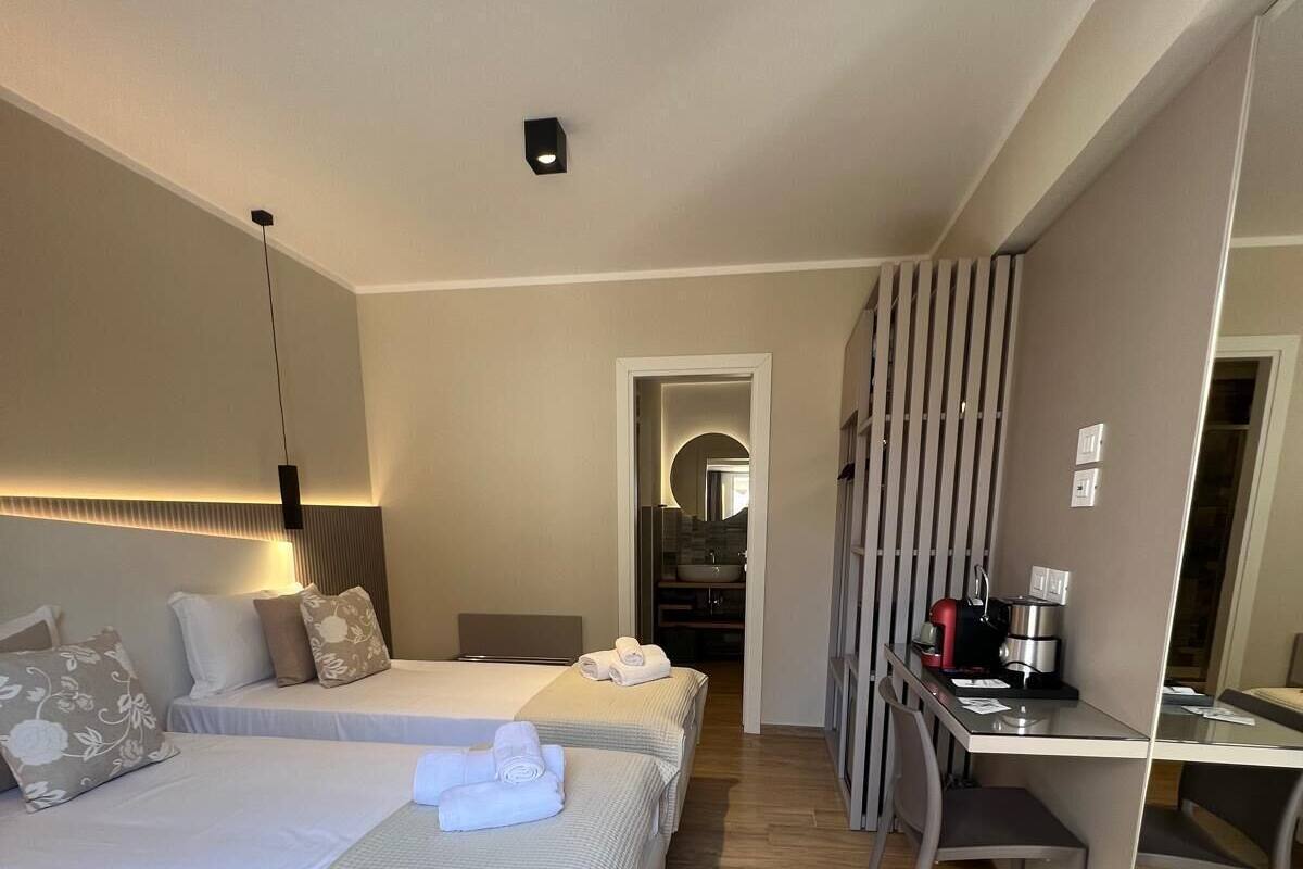 Een hotelkamer met twee bedden, een bureau en een douche.