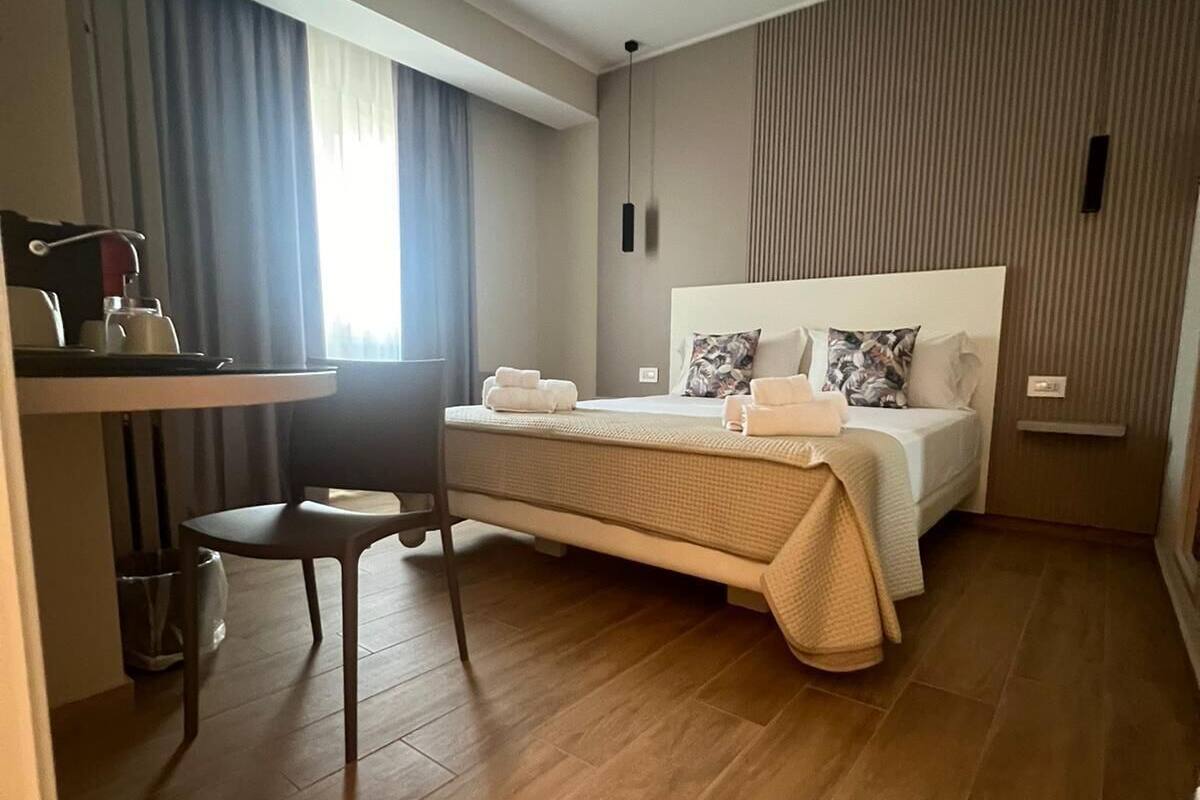 Een moderne hotelkamer met een groot bed, een bureau en een stoel.