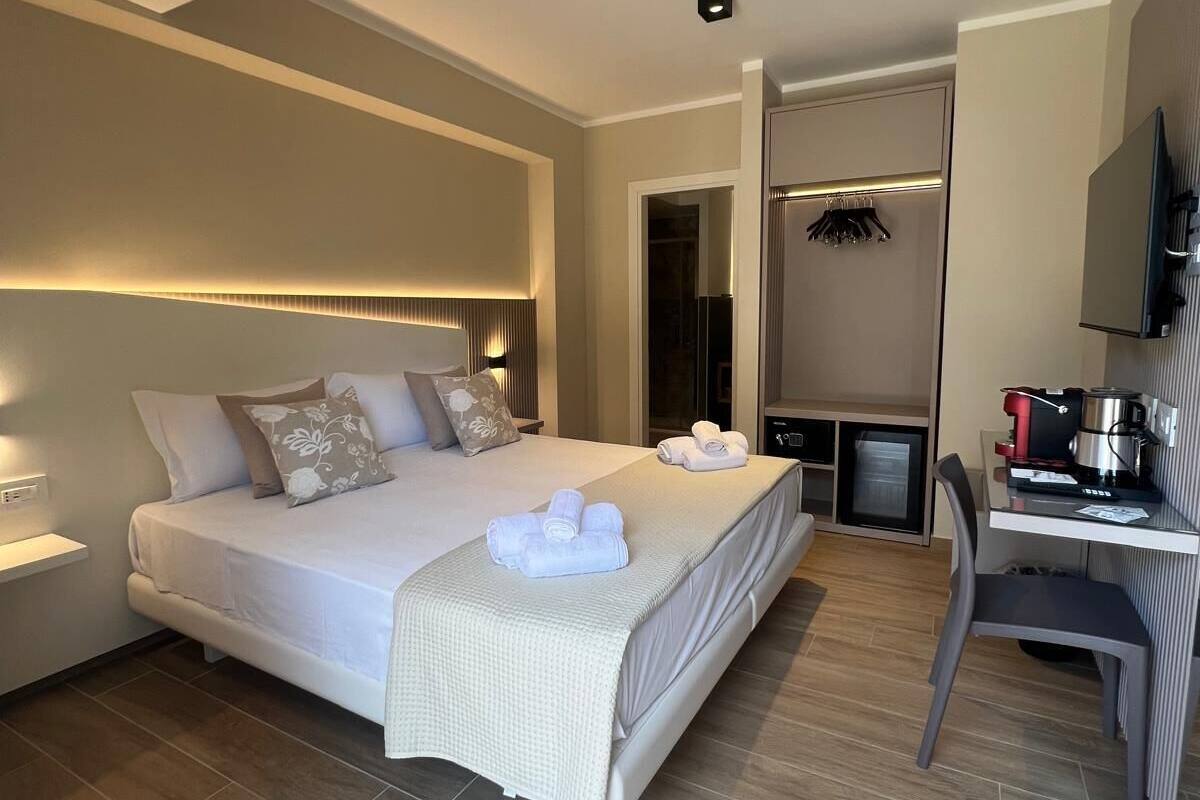 Een moderne hotelkamer met een groot bed, een bureau en een televisie.