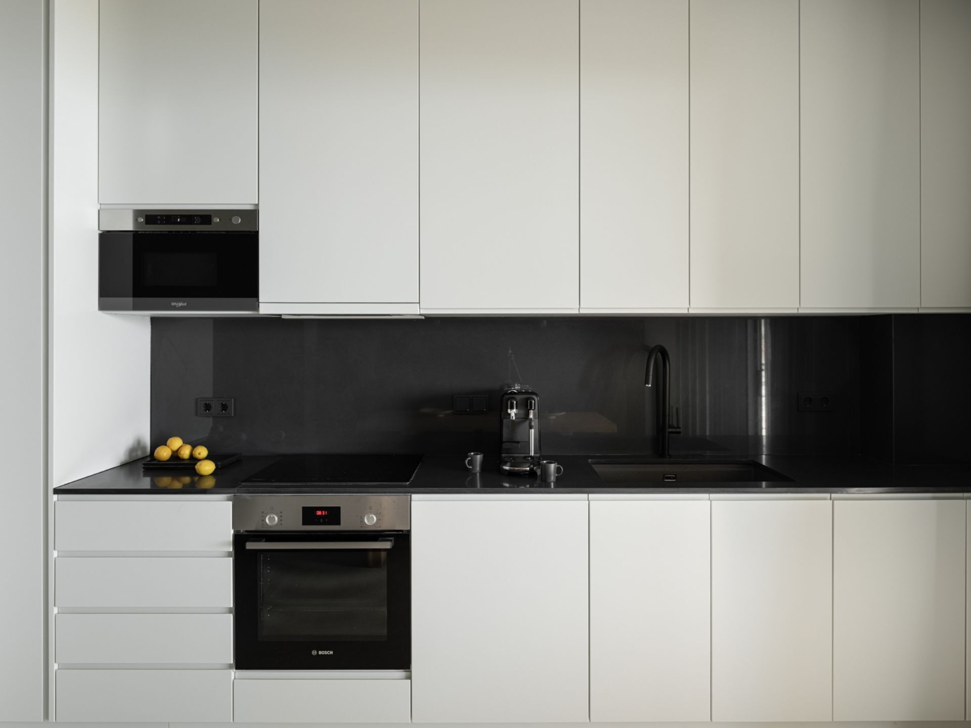A modern kitchen with stainless steel appliances, a microwave, a coffee maker, and a Bosch oven.