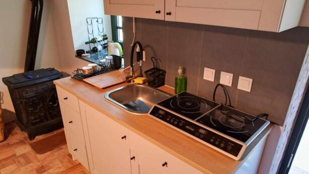 A modern kitchen with a wooden countertop, a built-in stove, and a sink. - Holiday Home Saniv (Batina)