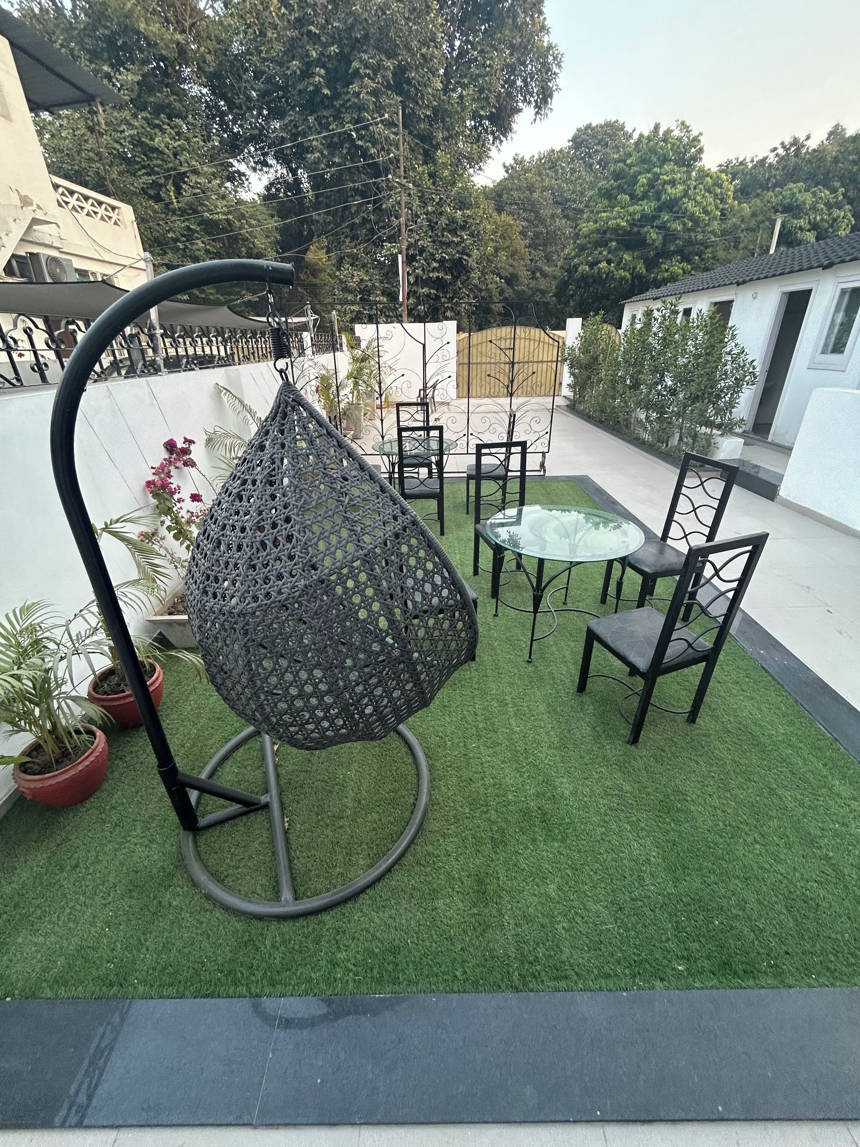 Un'area patio con prato artificiale, una sedia a dondolo, un tavolo e sedie.