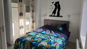 Un dormitorio con cama, aire acondicionado en la pared y puerta que da a otra habitación.