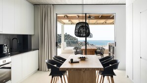A modern kitchen with white cabinets, a black countertop, and a built-in oven. - Design Villa Skioni by Halkidiki Villas (Kassandra)