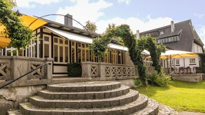 A stone staircase leading to a building with a yellow awning and a lattice fence.