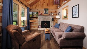 A cozy living room with a stone fireplace, wooden ceiling, and a large window with curtains. - Clean and cozy one bedroom for 2- mountain view, hot tub, cute as can be! (Gatlinburg)
