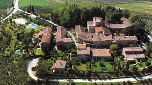 An aerial view of a historic estate with multiple buildings, a swimming pool, and surrounding vineyards. - Tuopina Chianti House [AC- Free Parking] (Topina)