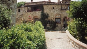 A stone building with a courtyard, featuring a gravel path and lush greenery. - Tuopina Chianti House [AC- Free Parking] (Topina)
