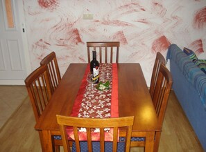 Ett matbord med en blommig duk, en vinflaska och två glas.