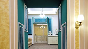 Een trap die leidt naar een kamer met teal muren, een kroonluchter en een witte kast.