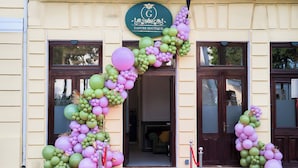 Entree van een boetiekhotel, met rode loper en een decoratieve ballonboog.