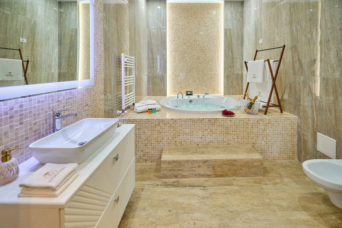 Une salle de bain moderne avec une grande baignoire, un lavabo séparé et un meuble-lavabo.