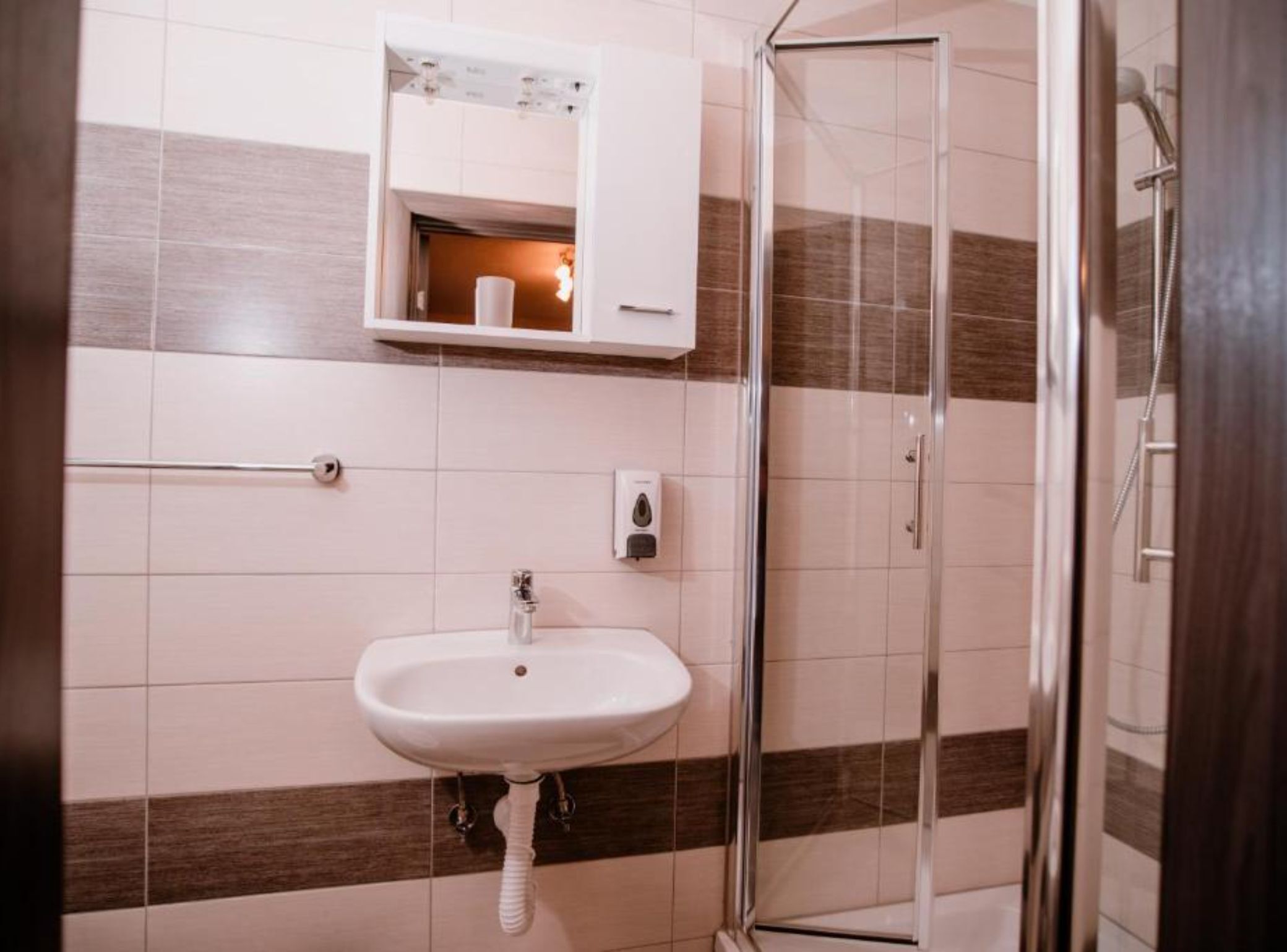 Une salle de bain avec un lavabo, un miroir et une douche.