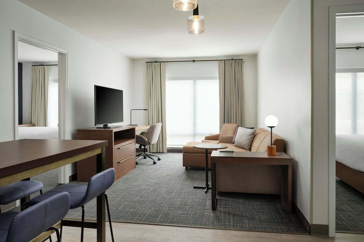 Habitación de hotel con escritorio, televisión, sofá y cama.