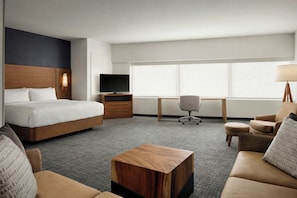 A hotel room with a bed, desk, office chair, sofa, and a small wooden table. - Residence Inn by Marriott Ventura Beach (Ventura)