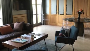 Un salon moderne comprenant un canapé, une table basse et un coin repas avec des chaises et une table.