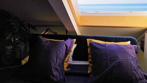 Ein Zimmer mit Oberlichter und Blick auf einen Strand.