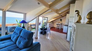 Ein geräumiges Loft mit hohen Decken, einem Essbereich und Meerblick.