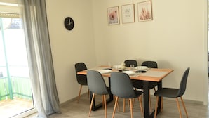 A dining area with a table set for four, six chairs, a clock, and three framed pictures on the wall. - Vacation apartment Taubersonne (Igersheim)