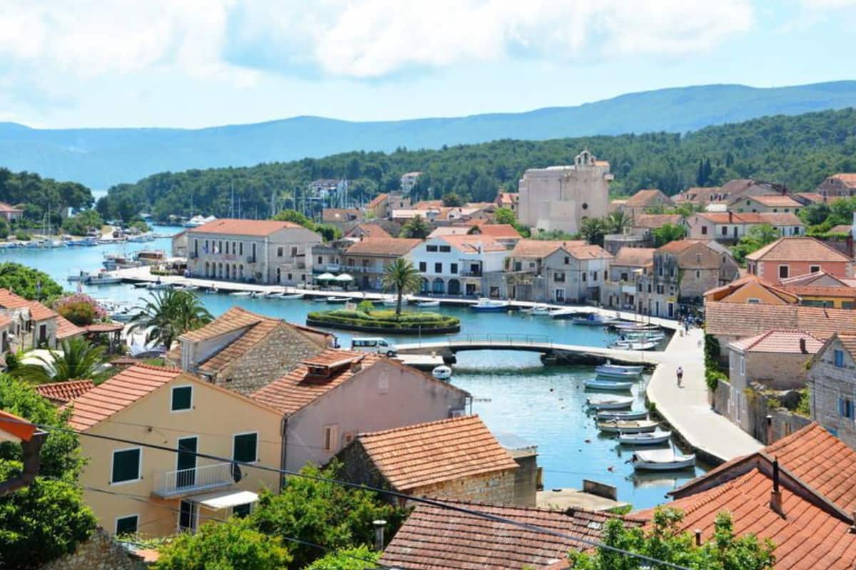 A coastal town with a marina, historic buildings, and a bridge.