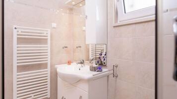A modern bathroom with a white sink, a mirror, and a towel rack.