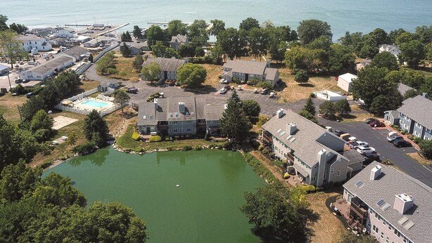 Vista aérea de una zona residencial con casas, una piscina y un lago.