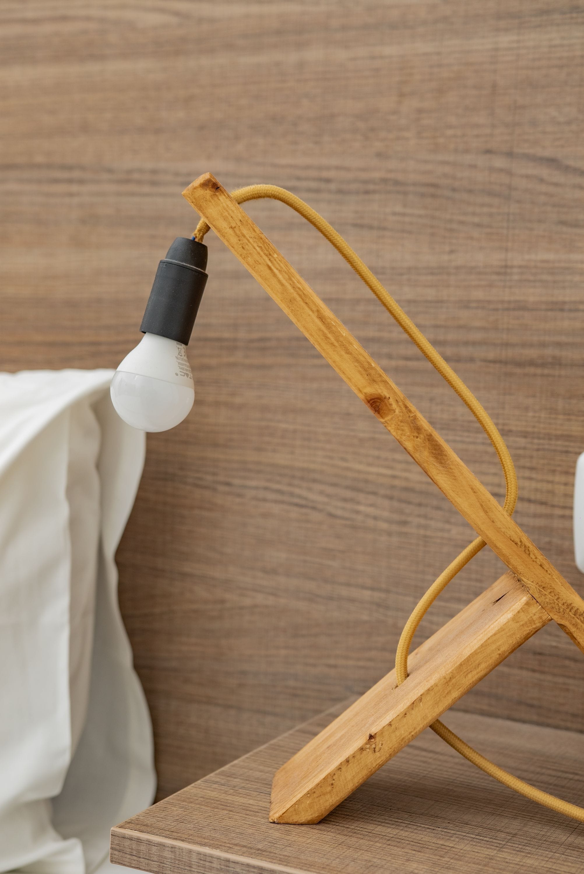 A wooden desk lamp with a white bulb.