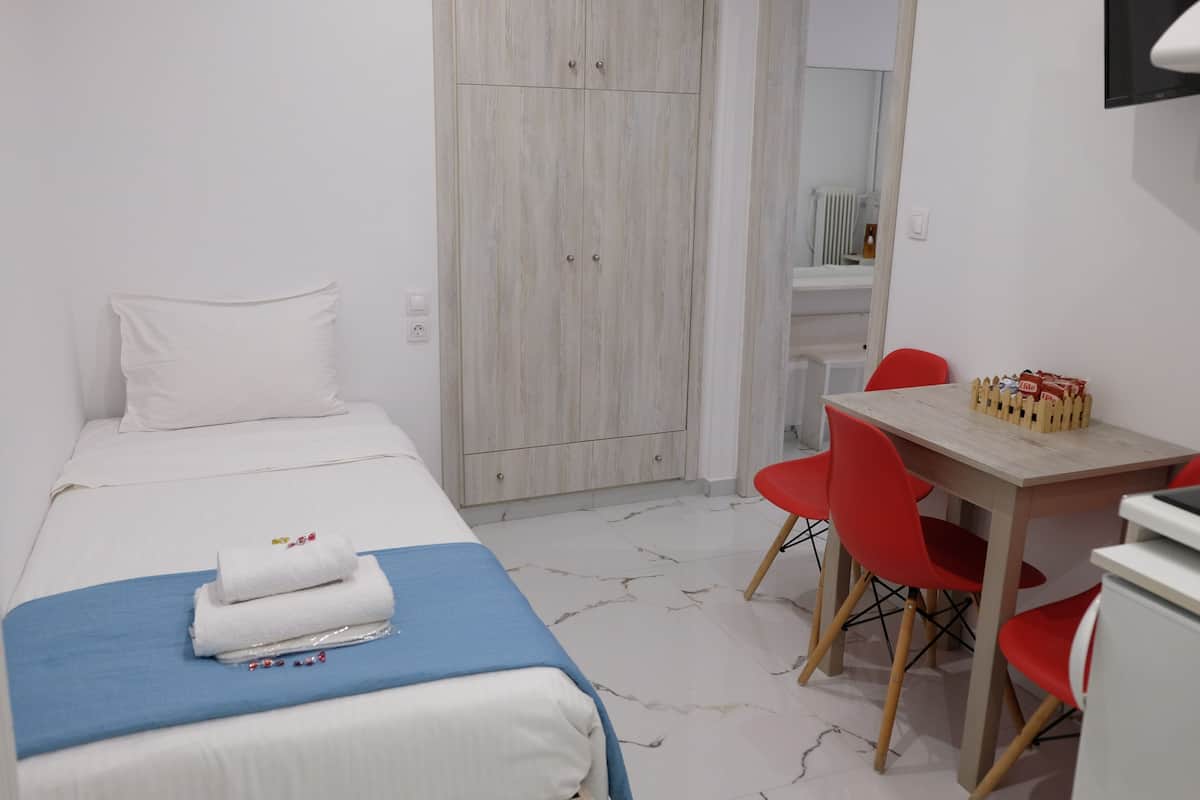 A hotel room with a bed, a desk, and a chair.