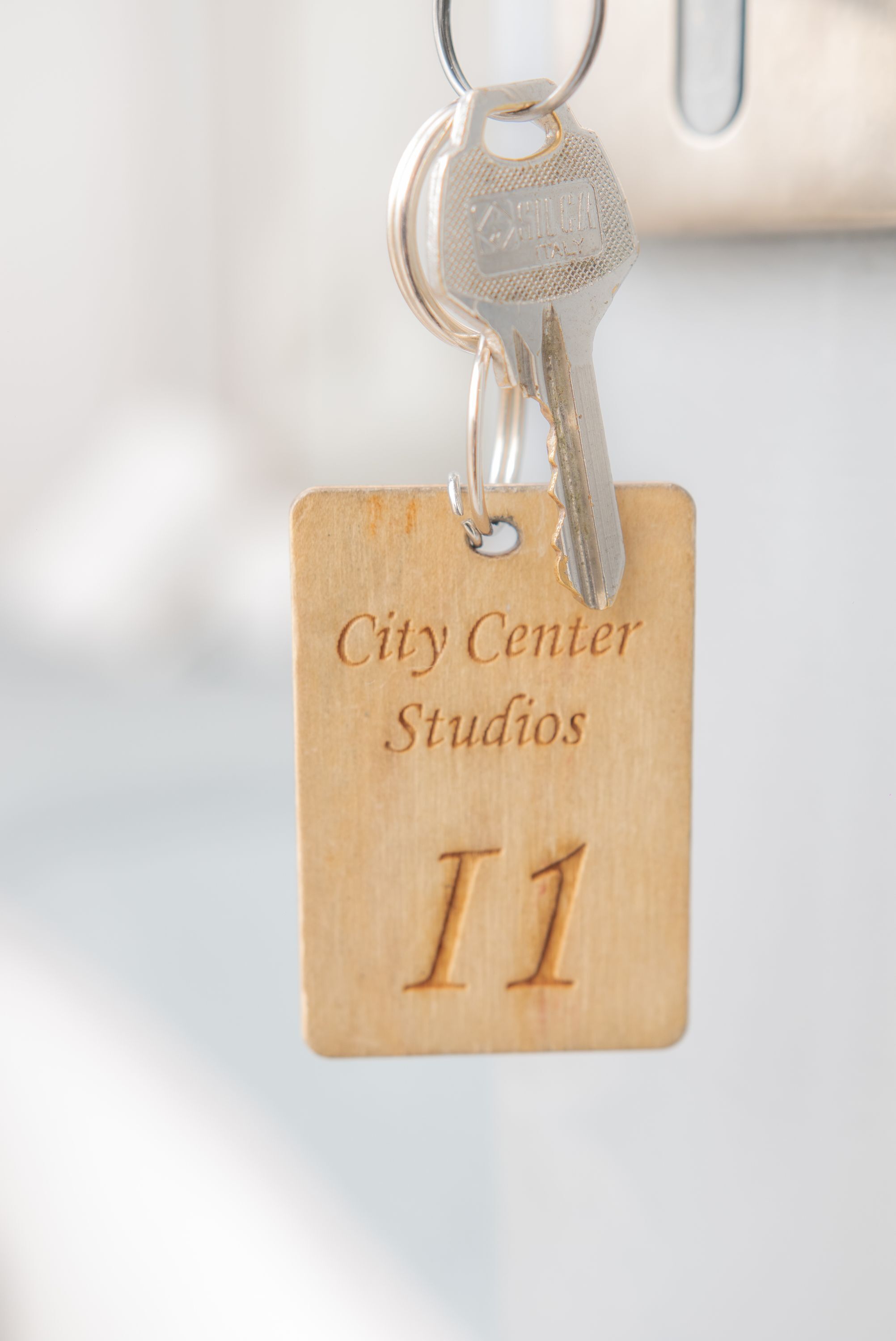 Un porte-clés avec une étiquette en bois portant l’inscription « City Center Studios » et le numéro « T1 ».