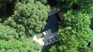 An aerial view of a lush green landscape with a water feature and a paved area. - mar-A-mar_Brand New Town House (Puntarenas)