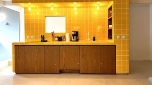A modern kitchen with yellow tiles, wooden cabinets, and a built-in island. - Brand New Town House (Puntarenas)