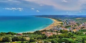 A coastal town with a beach, houses, and greenery. - Appartamenti Della Rosa Seaside Abruzzo (Martinsicuro)