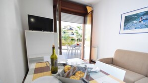 Un comedor con una mesa preparada para dos personas, una botella de vino y una hogaza de pan.