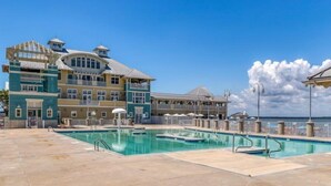 A hotel with a large pool area, multiple balconies, and a clear view of the ocean. - Sunset Island-Fountain Drive 39-3F-Bayside 67th St, Free WiFi, Pool, Elev, W/D, AC (Ocean City)