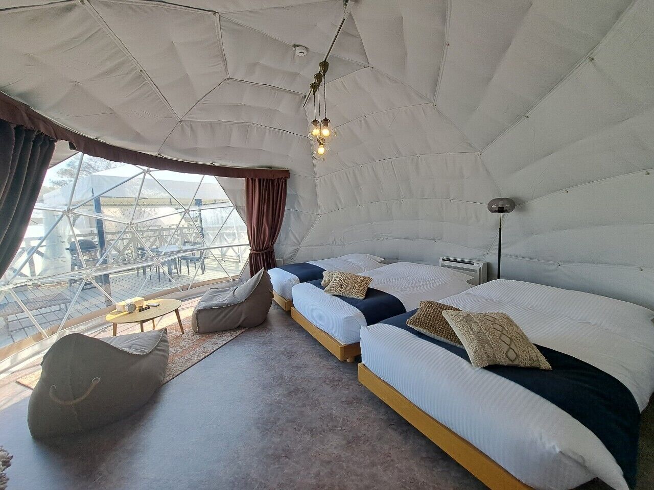A cozy room with a large bed, a seating area, and a view of the outside.