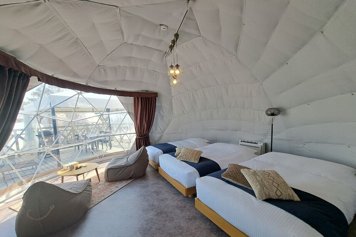 A cozy room with a large bed, a seating area, and a view of the outside.