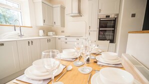 Una cocina con armarios blancos, un lavabo y un horno.
