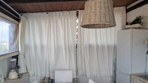 Un comedor con una mesa, sillas, una lámpara colgante y un refrigerador.