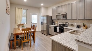 A modern kitchen with a dining area, stainless steel appliances, granite countertops, and light wood cabinetry. - 6 Mi to Lackland Afb: Hot Tub, Pool & Game Room! (San Antonio)