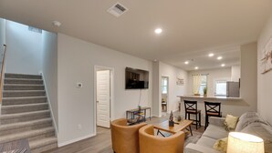 A spacious living room with a staircase, a dining area, and a kitchen. - 6 Mi to Lackland Afb: Hot Tub, Pool & Game Room! (San Antonio)