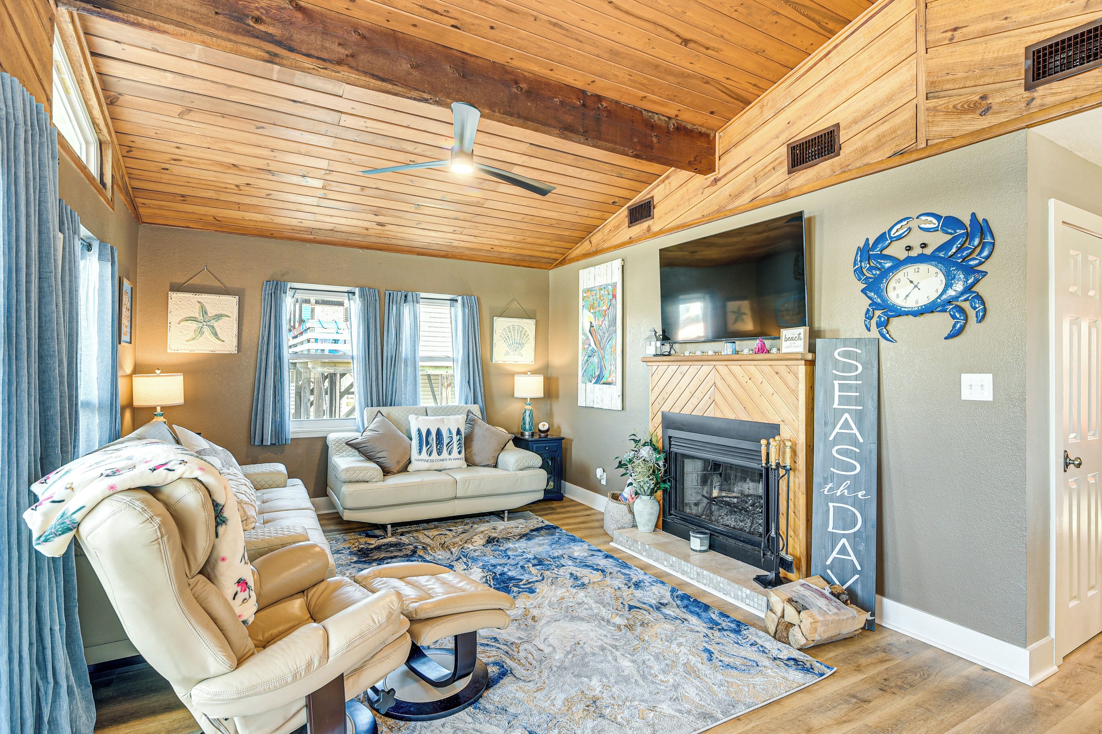 A cozy living room with a fireplace, a large rug, and a couch.