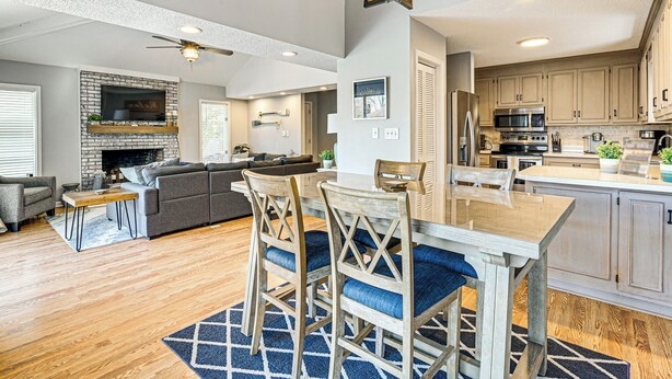 A spacious living area with a fireplace, a dining table with chairs, and a kitchen with modern appliances. - 1 Mi to Broadway at the Beach: Home w/ Large Yard! (Myrtle Beach)