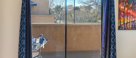 A room with a sliding glass door leading to a balcony.